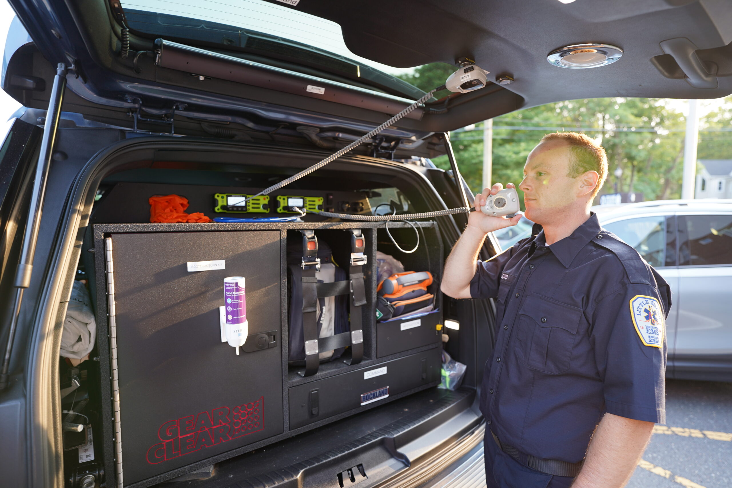 Volunteer standing at a vehicle communicating via radio